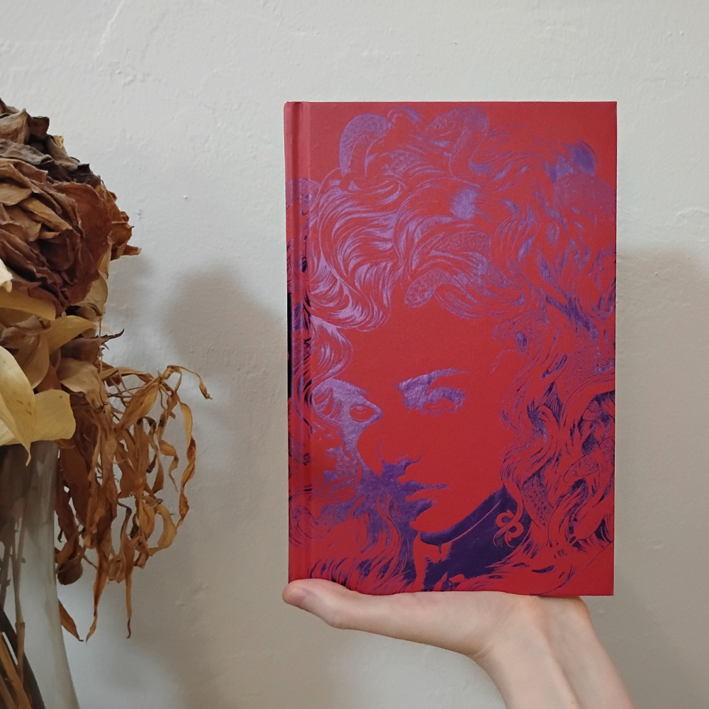 The bare hardcover is red and has sort of an outline of the same girl's face in shiny purple foil.