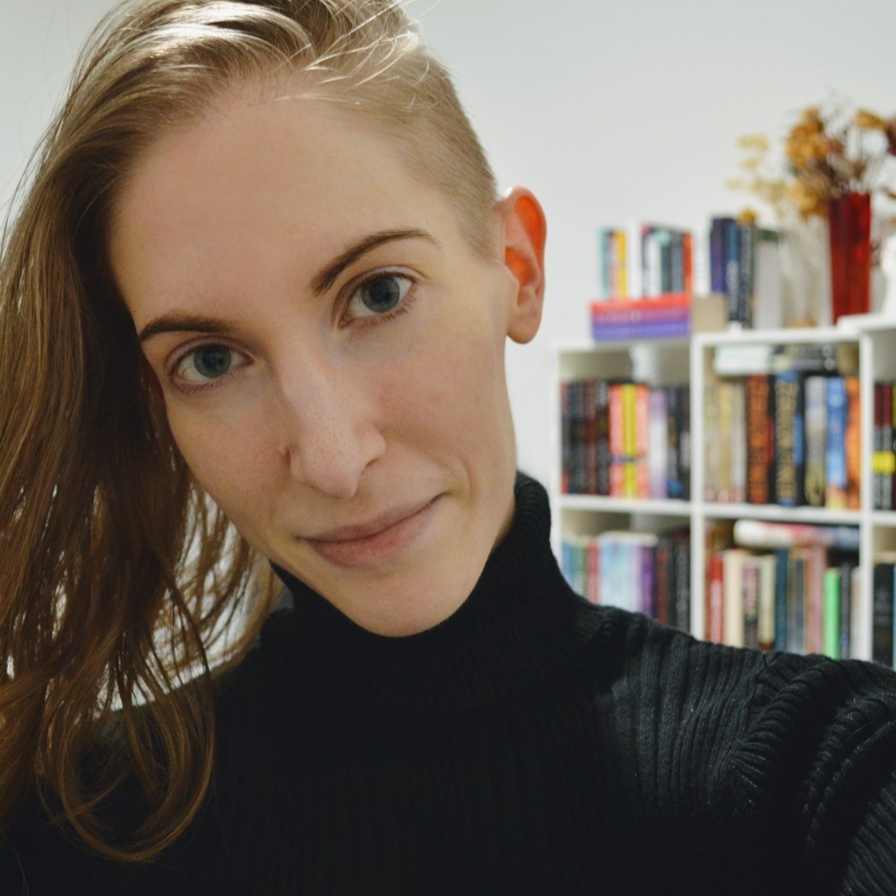 photo of myself wearing a black turtleneck, dark blonde hair shaved on the sides and shoulder length on top
